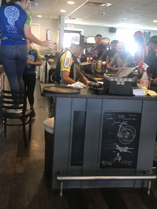 Riders crowded around the bar, bike patent art below the counter